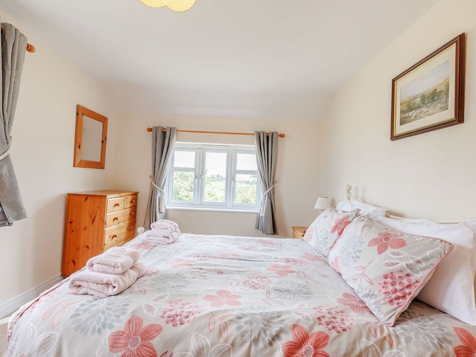 A bedroom with a bed and wooden furniture at Wood Cottage in Tenbury Wells