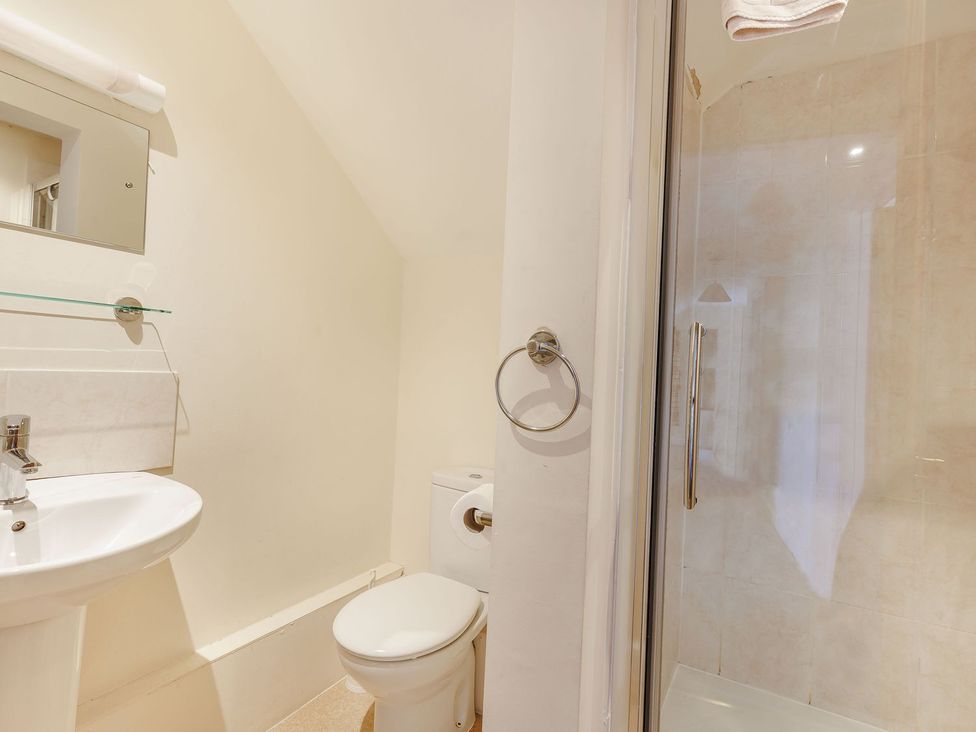 A bathroom with a sink, toilet, and shower at Wood Cottage in Tenbury Wells