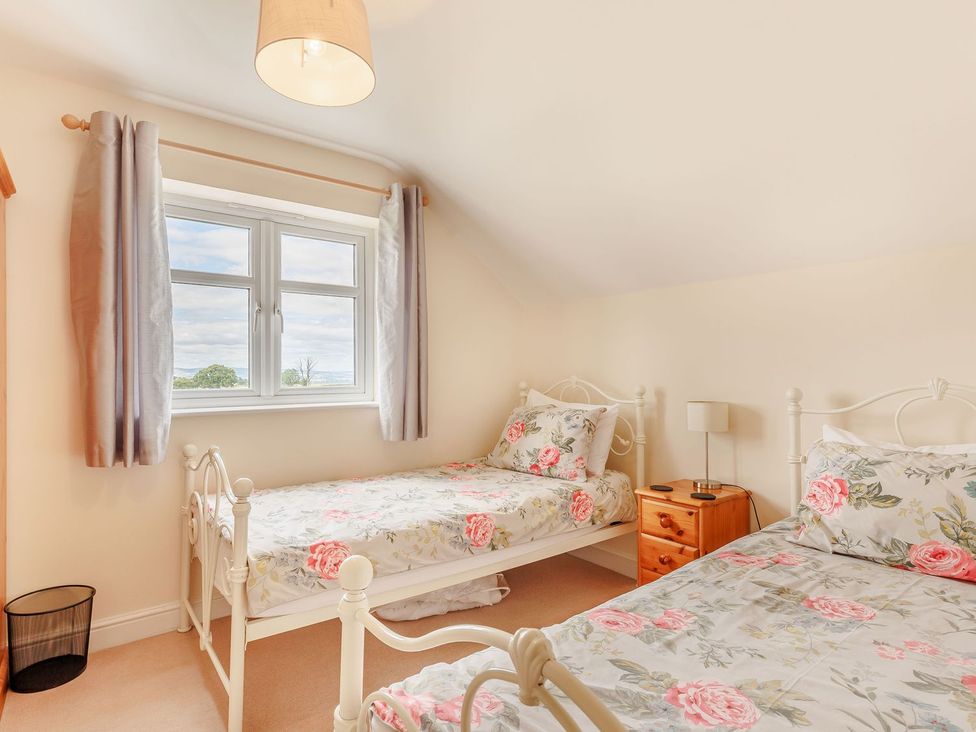 A bedroom with two beds and a window at Wood Cottage in Tenbury Wells