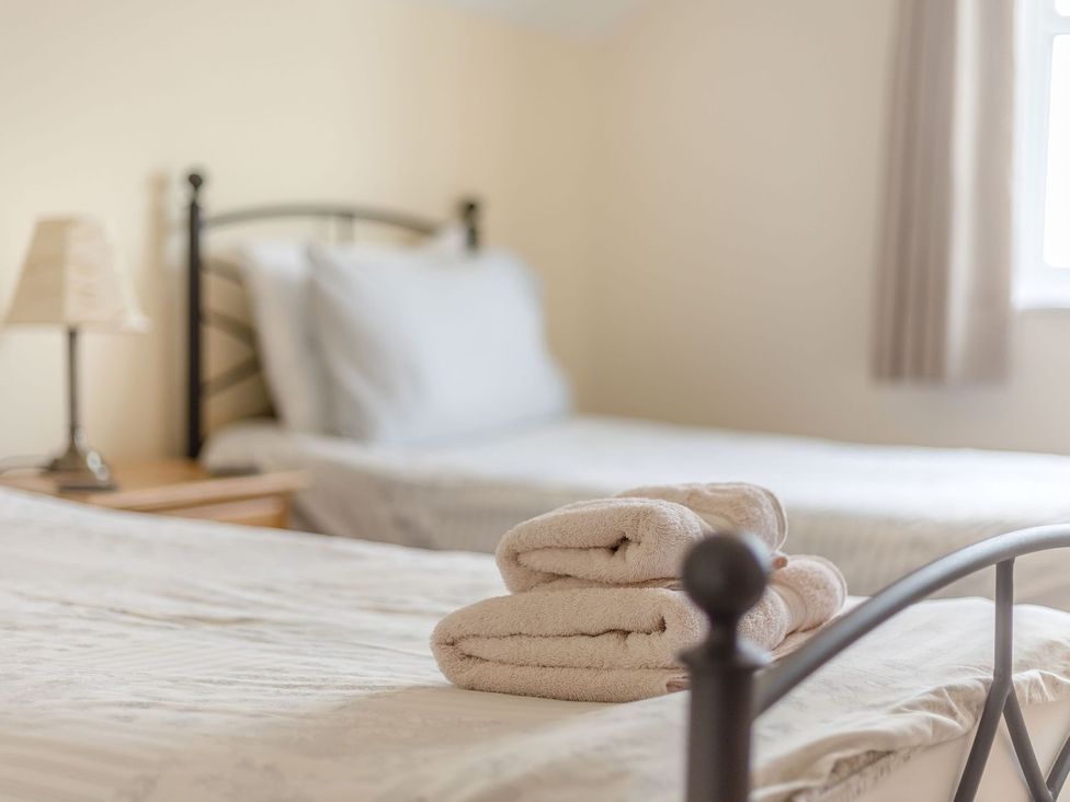 A bedroom with beds and towels at Wood Cottage in Tenbury Wells