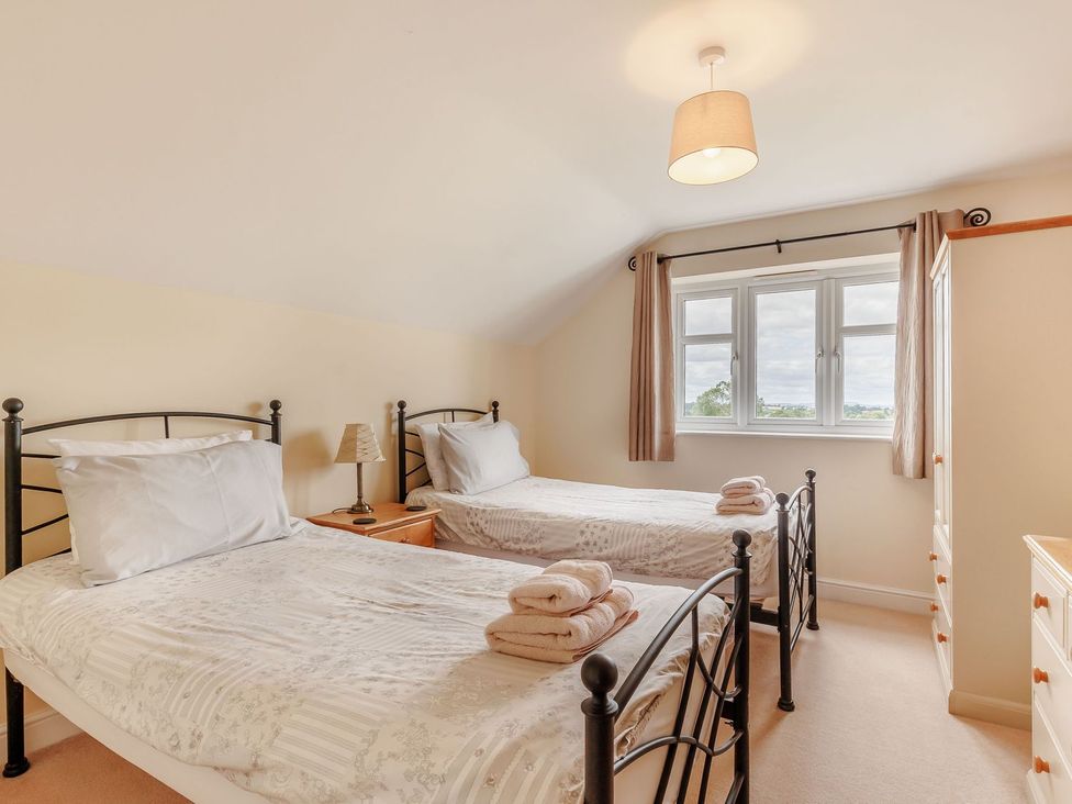 A bedroom with two single beds and a window at Wood Cottage in Tenbury Wells