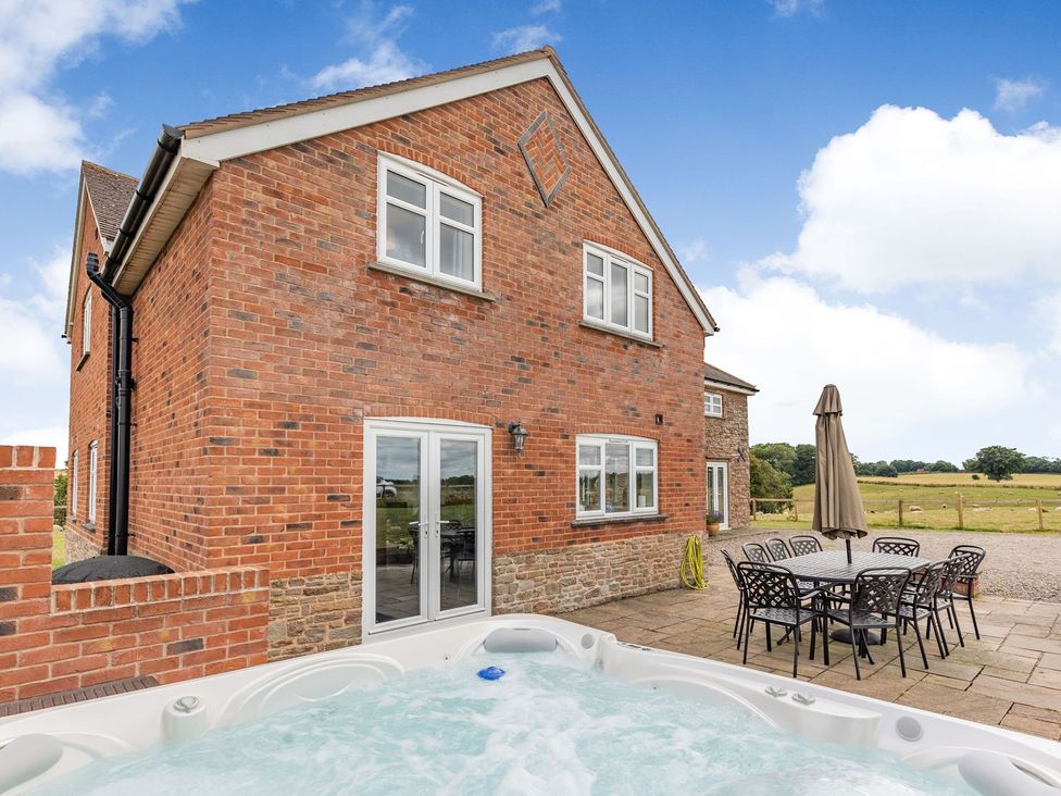 An outdoor space featuring a hot tub and seating area at Wood Cottage Tenbury Wells