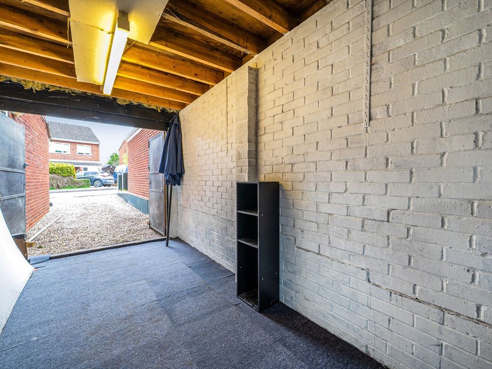 A garage with a shelf and open doors at Wood Cottage in Tenbury Wells