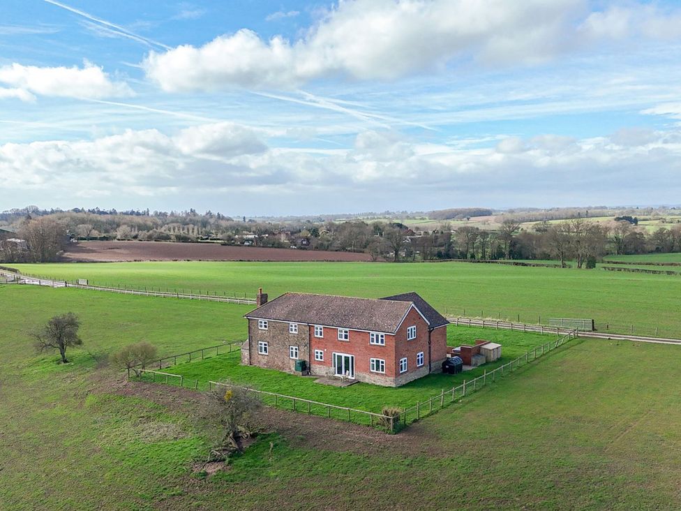 A house surrounded by fields and trees at Wood Cottage in Tenbury Wells