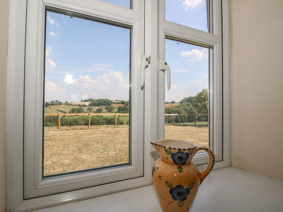 A pitcher on a windowsill with a view at Wood Cottage in Tenbury Wells