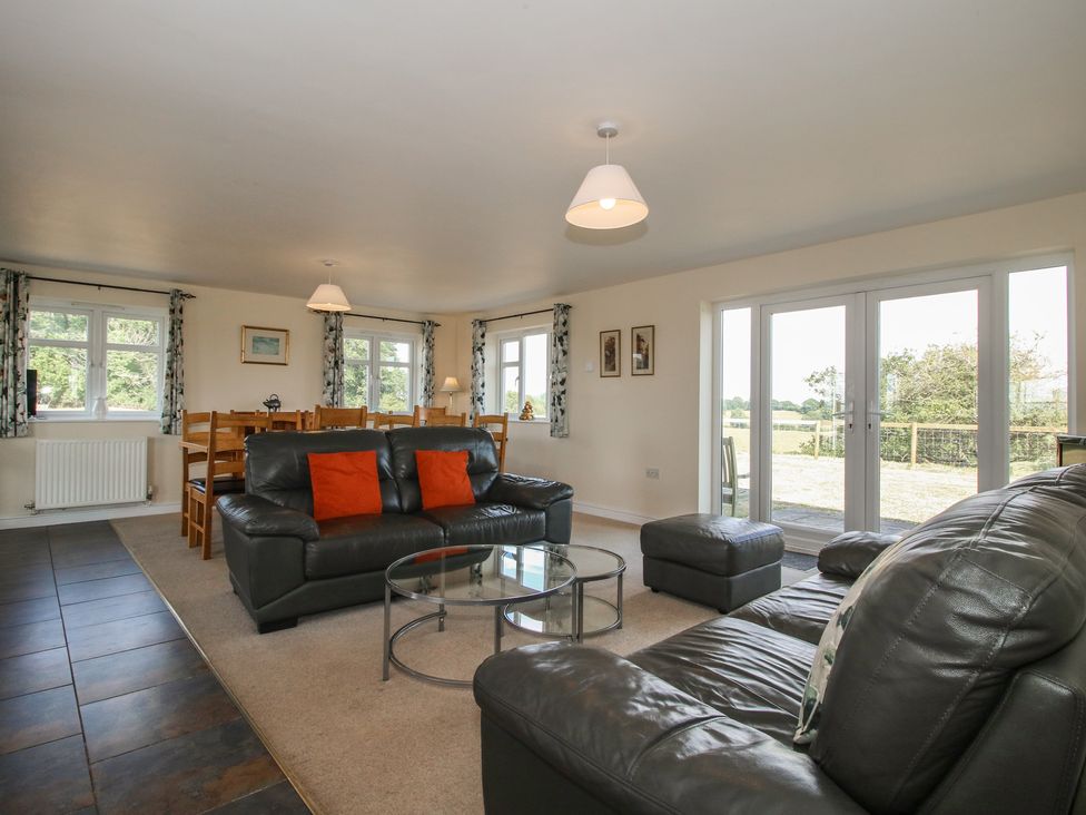 A living room with a sofa and dining area at Wood Cottage in Tenbury Wells