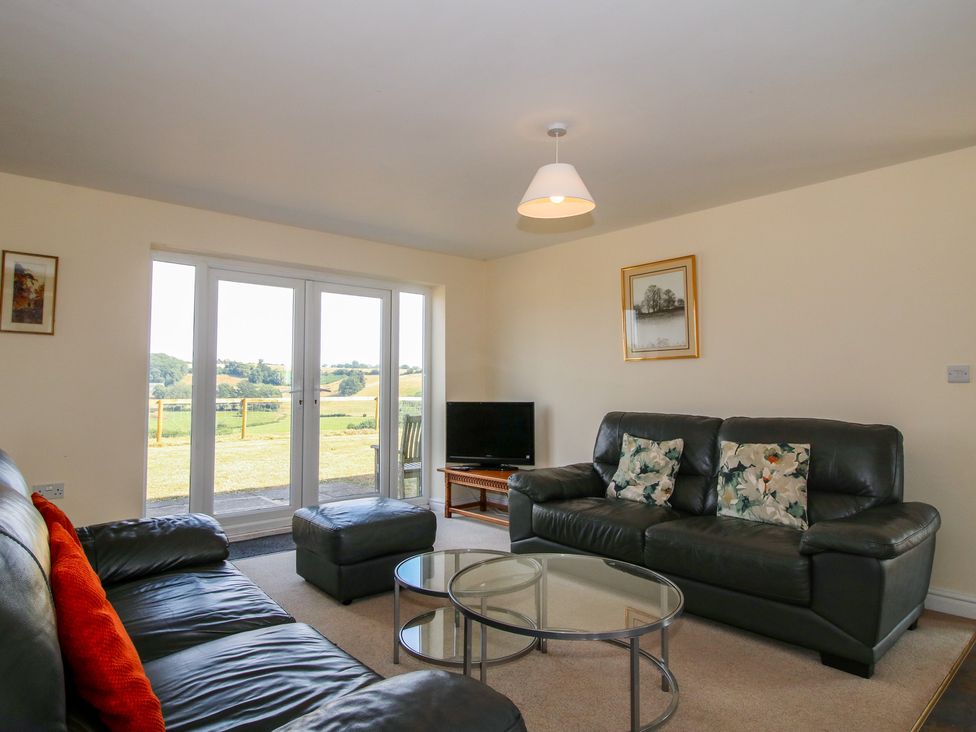A living room with a television and sofa at Wood Cottage in Tenbury Wells