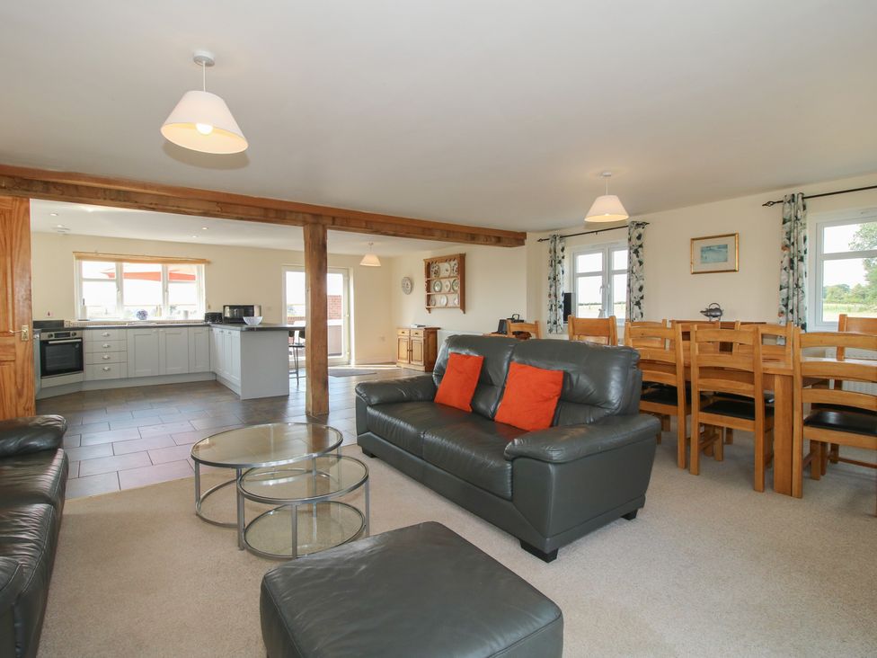 A living room and kitchen area with a dining table at Wood Cottage in Tenbury Wells