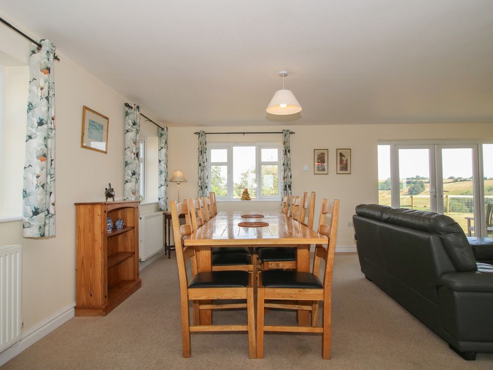 A dining room with a large table and chairs at Wood Cottage in Tenbury Wells