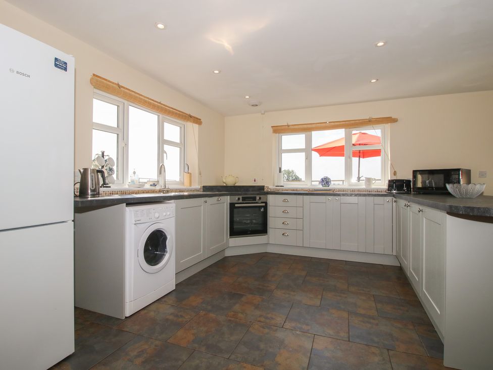 A kitchen with appliances and windows at Wood Cottage in Tenbury Wells