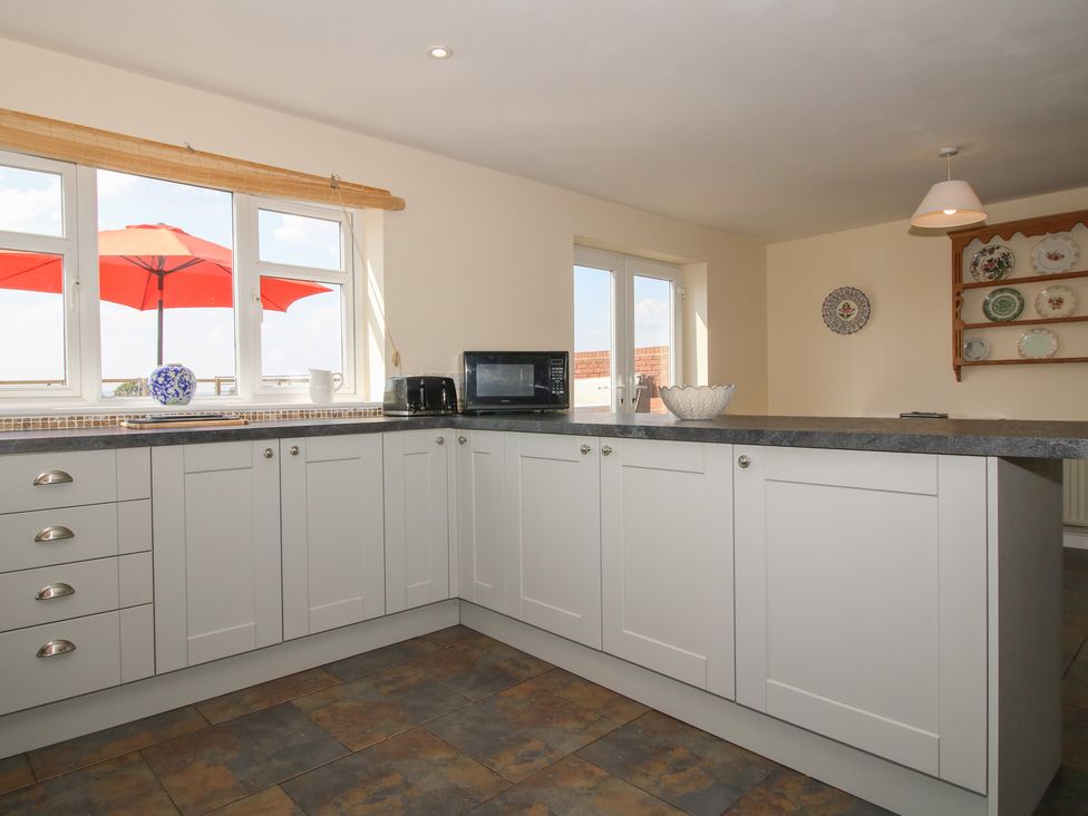 A kitchen with cabinets and a microwave at Wood Cottage in Tenbury Wells