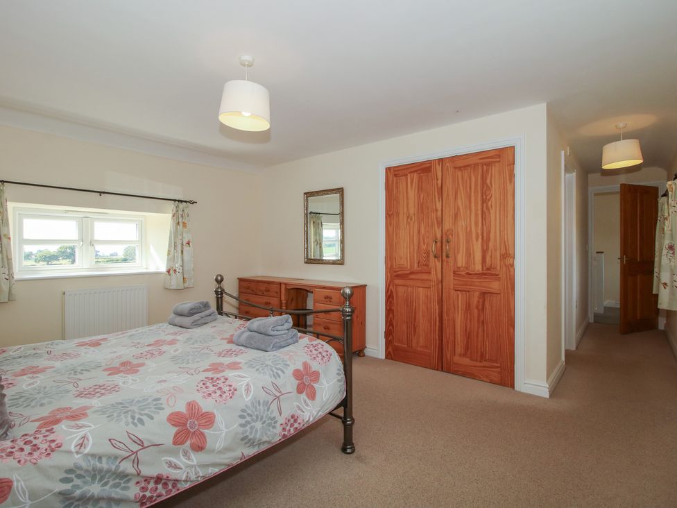 A bedroom with a bed and a dressing table at Wood Cottage in Tenbury Wells