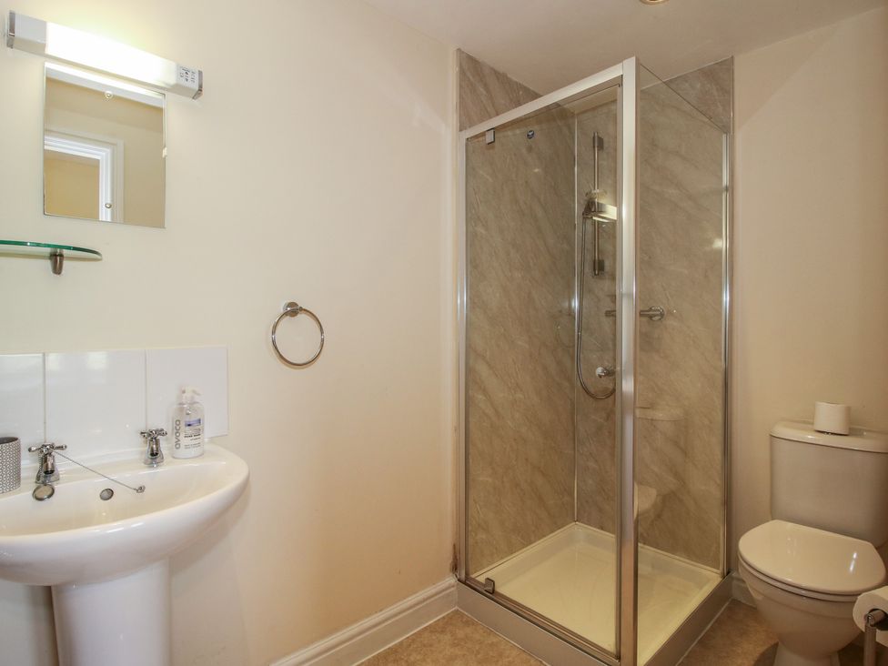 A bathroom with a shower enclosure, wash basin, and toilet at Wood Cottage Tenbury Wells