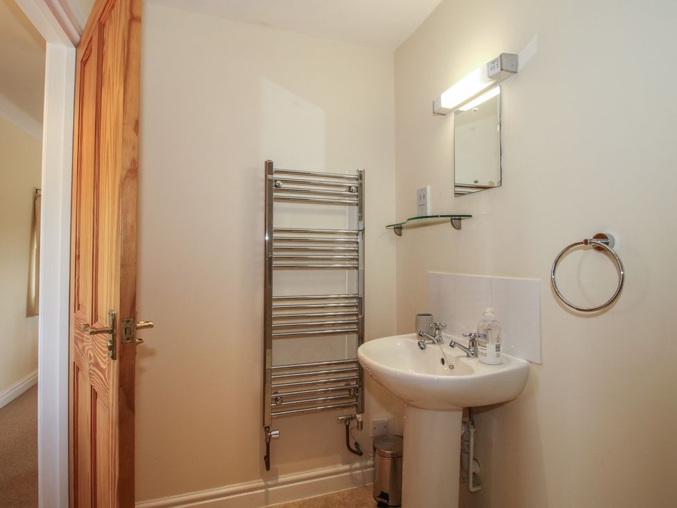 A bathroom with a sink and towel rack at Wood Cottage in Tenbury Wells