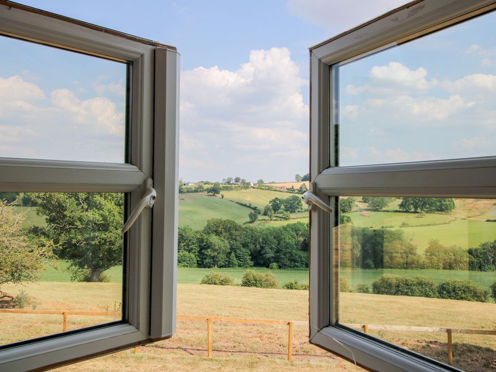 A window view showing fields and trees at Wood Cottage in Tenbury Wells