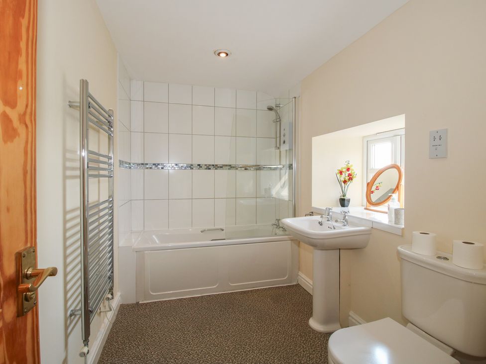 A bathroom with a bath, sink, and toilet at Wood Cottage in Tenbury Wells