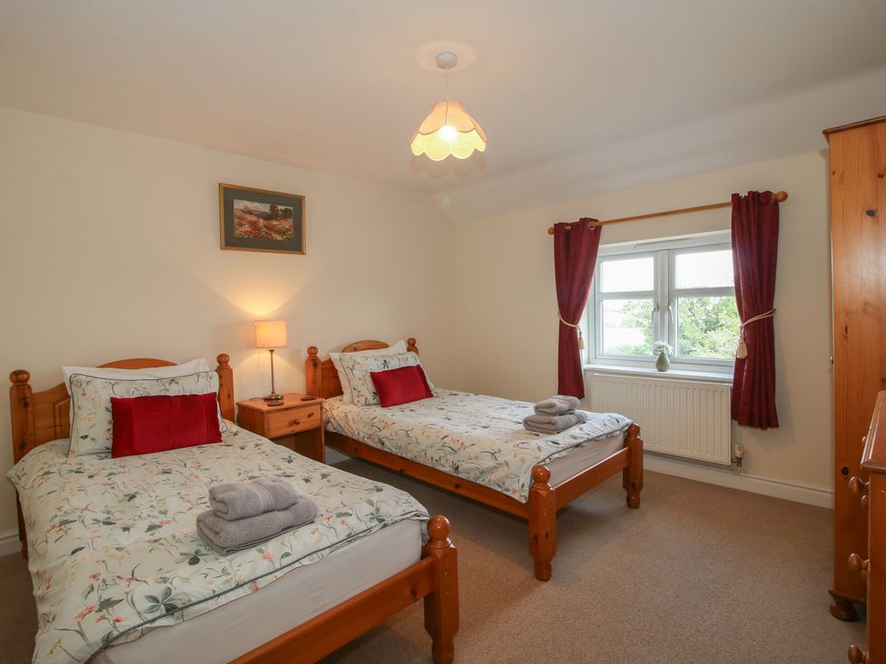 A bedroom with two beds and a window at Wood Cottage in Tenbury Wells