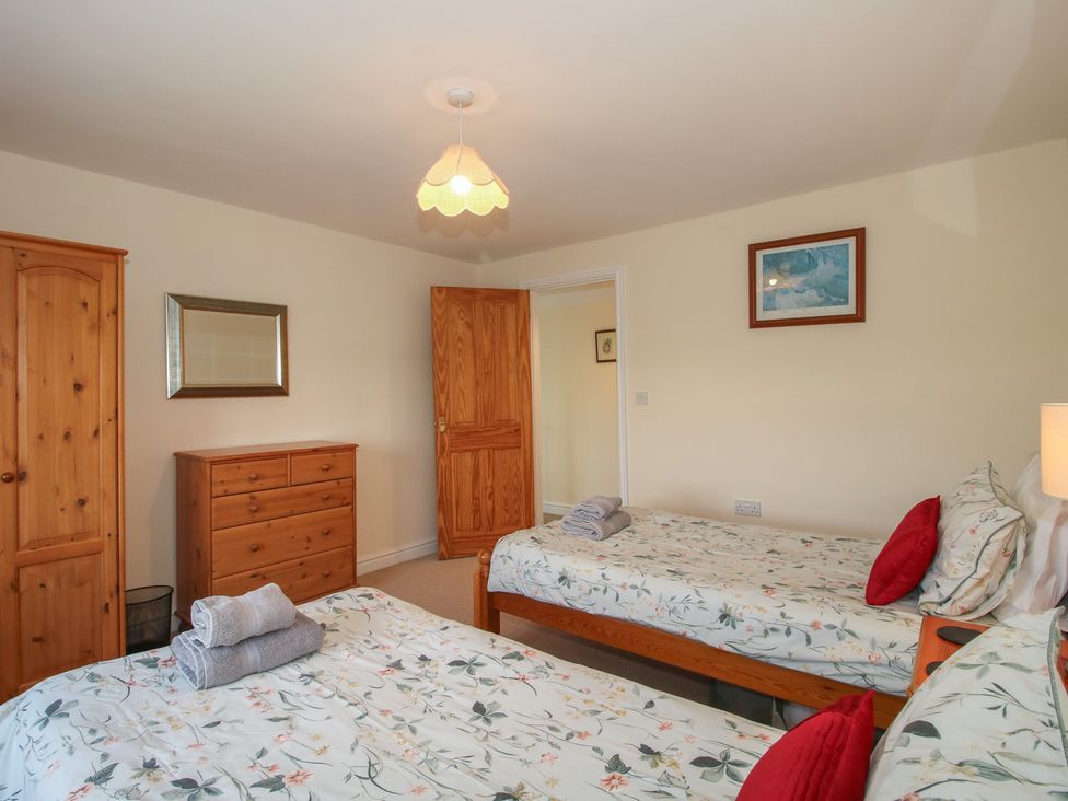 A bedroom with two single beds and wooden furniture at Wood Cottage in Tenbury Wells