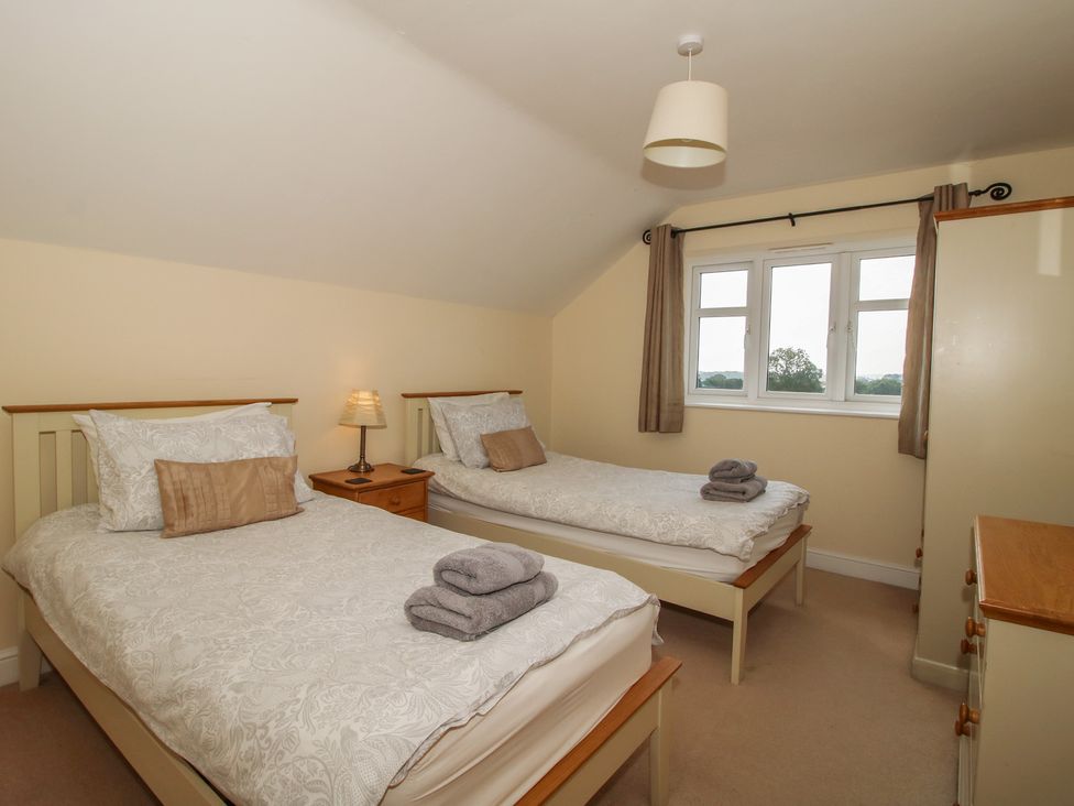 A bedroom with two single beds and a window at Wood Cottage in Tenbury Wells