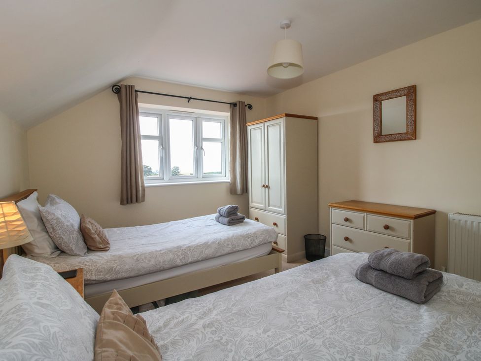 A bedroom with two beds and furniture at Wood Cottage Tenbury Wells