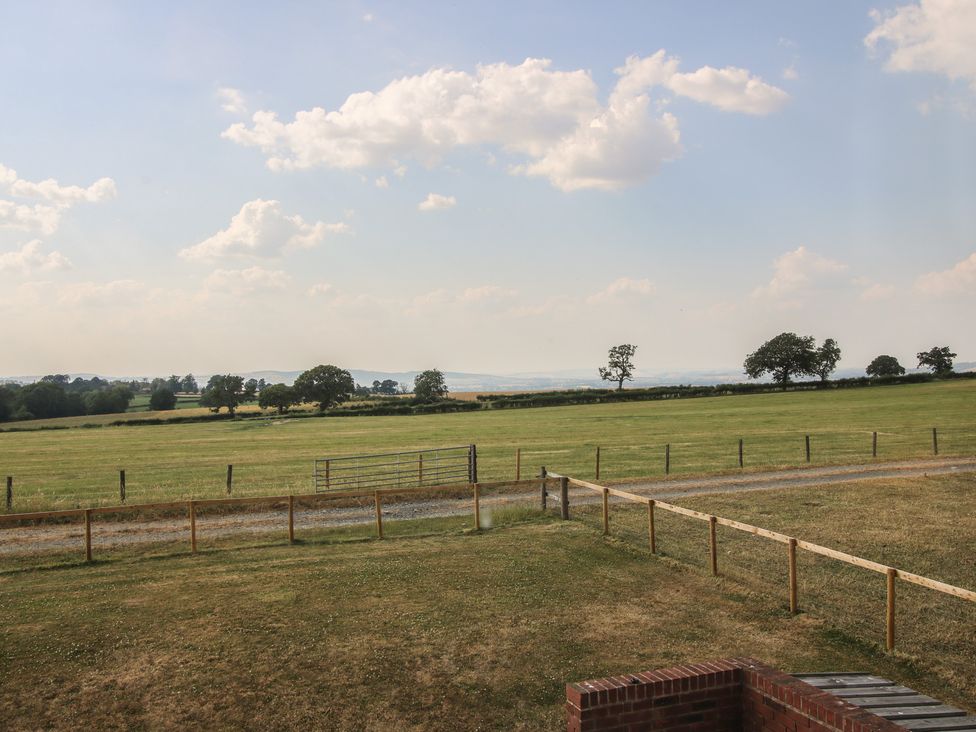 A field with a fence and trees at Wood Cottage in Tenbury Wells