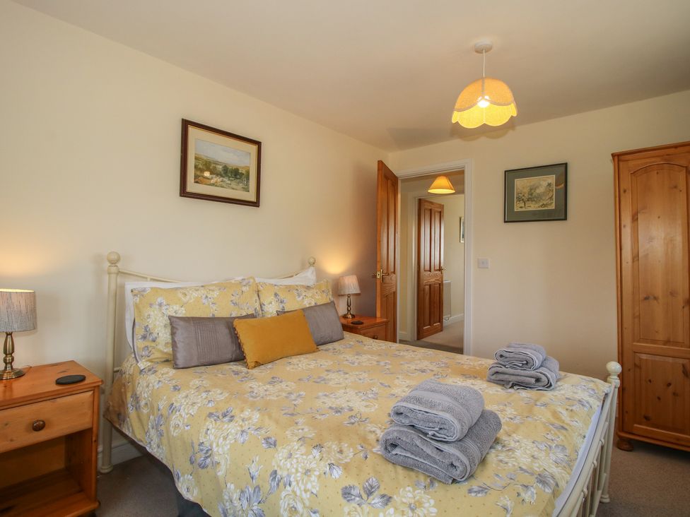 A bedroom with a bed and bedside lamps at Wood Cottage Tenbury Wells