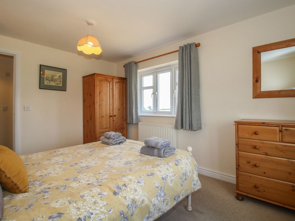 A bedroom with a bed and wardrobe at Wood Cottage Tenbury Wells