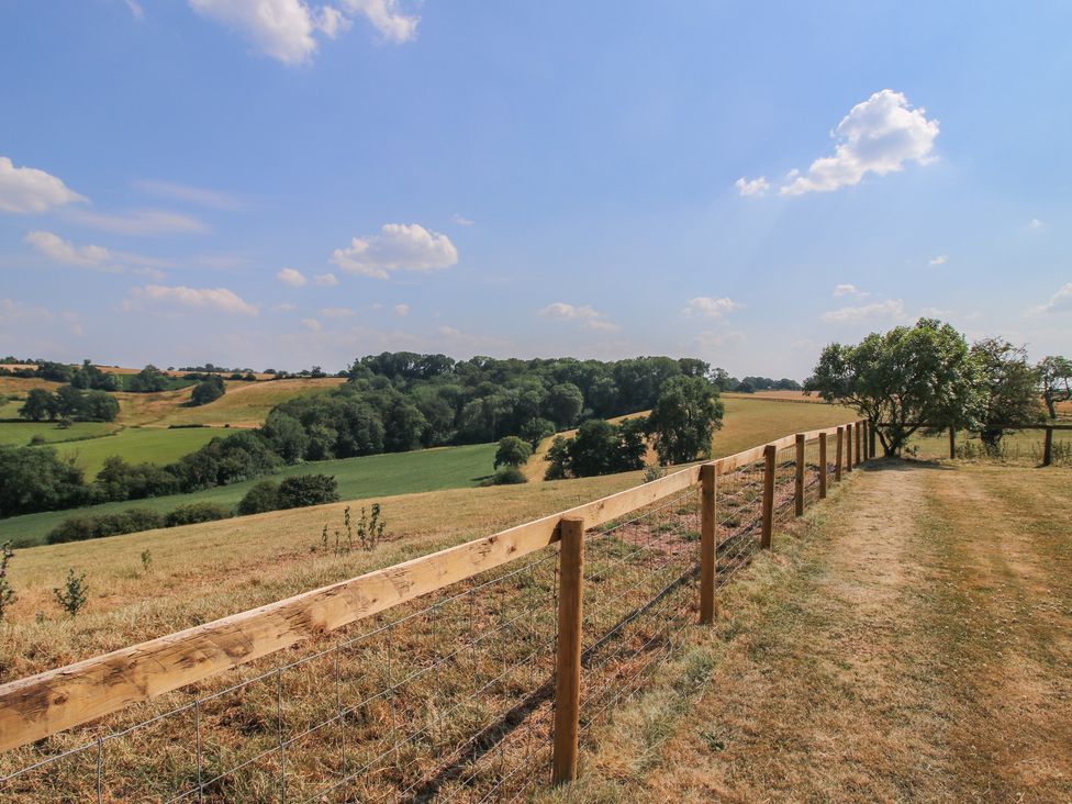 A landscape with a wooden fence and fields at Wood Cottage in Tenbury Wells