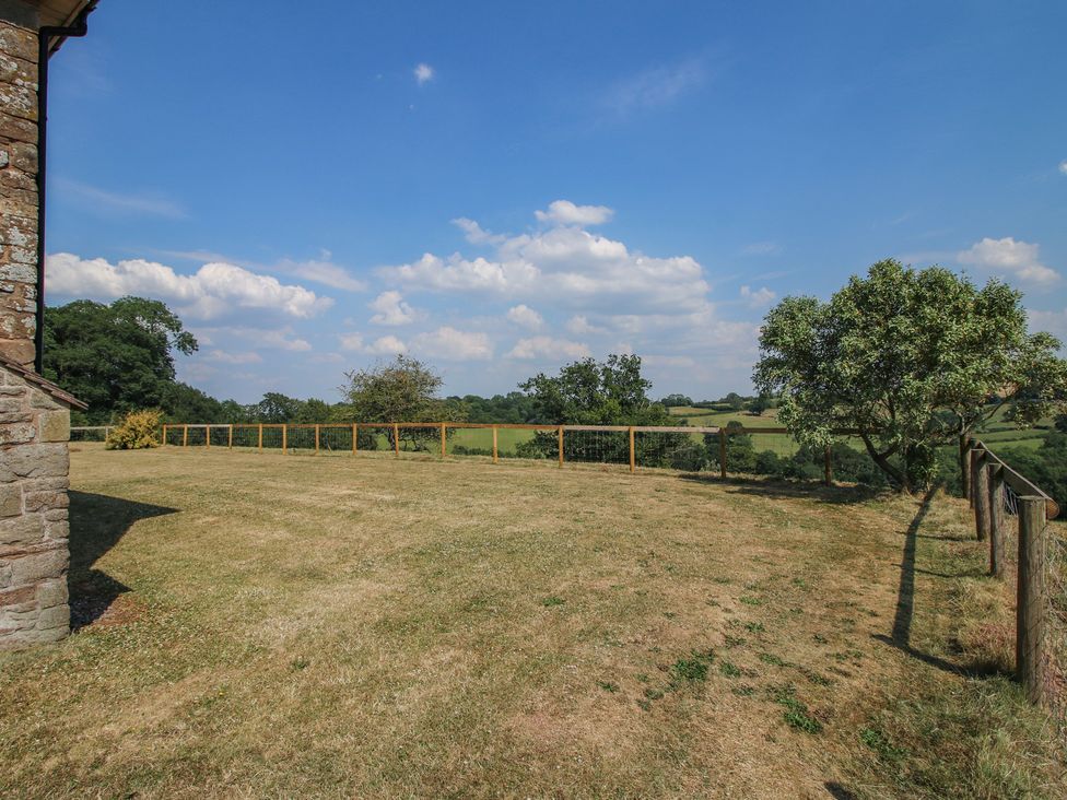 An outdoor area with grass, a tree, and a fence at Wood Cottage in Tenbury Wells