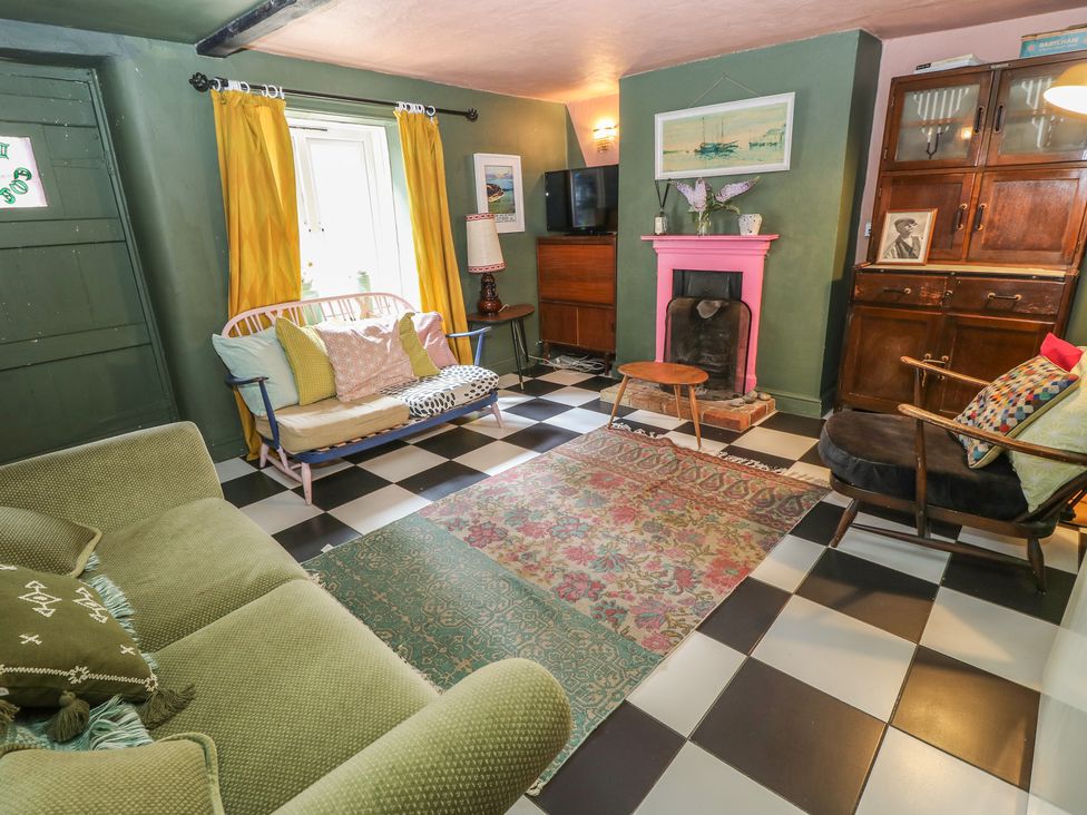 A living room with a sofa, rug, and coffee table at Dairy Cottage in Whitwell near Niton