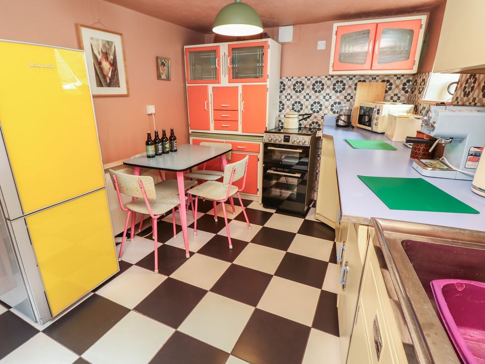 A kitchen with a table and chairs at Dairy Cottage in Whitwell near Niton