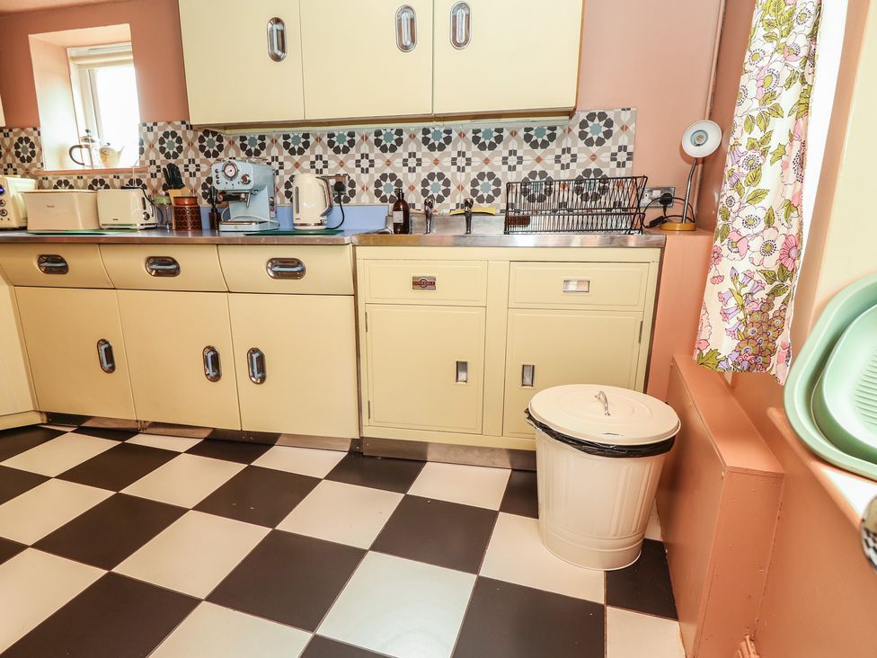 A kitchen with cabinets and appliances at Dairy Cottage in Whitwell near Niton