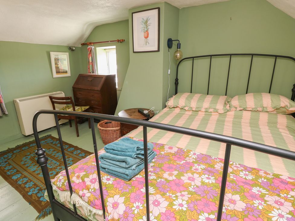 A bedroom with a bed and furniture at Dairy Cottage in Whitwell near Niton