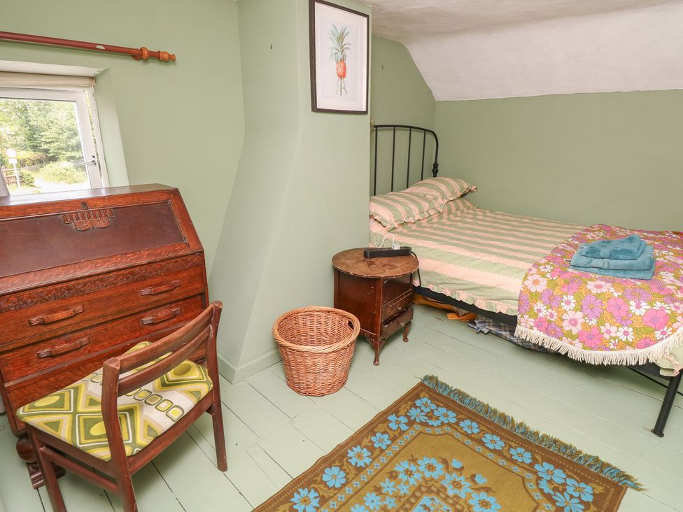 A bedroom with a bed and desk at Dairy Cottage in Whitwell near Niton