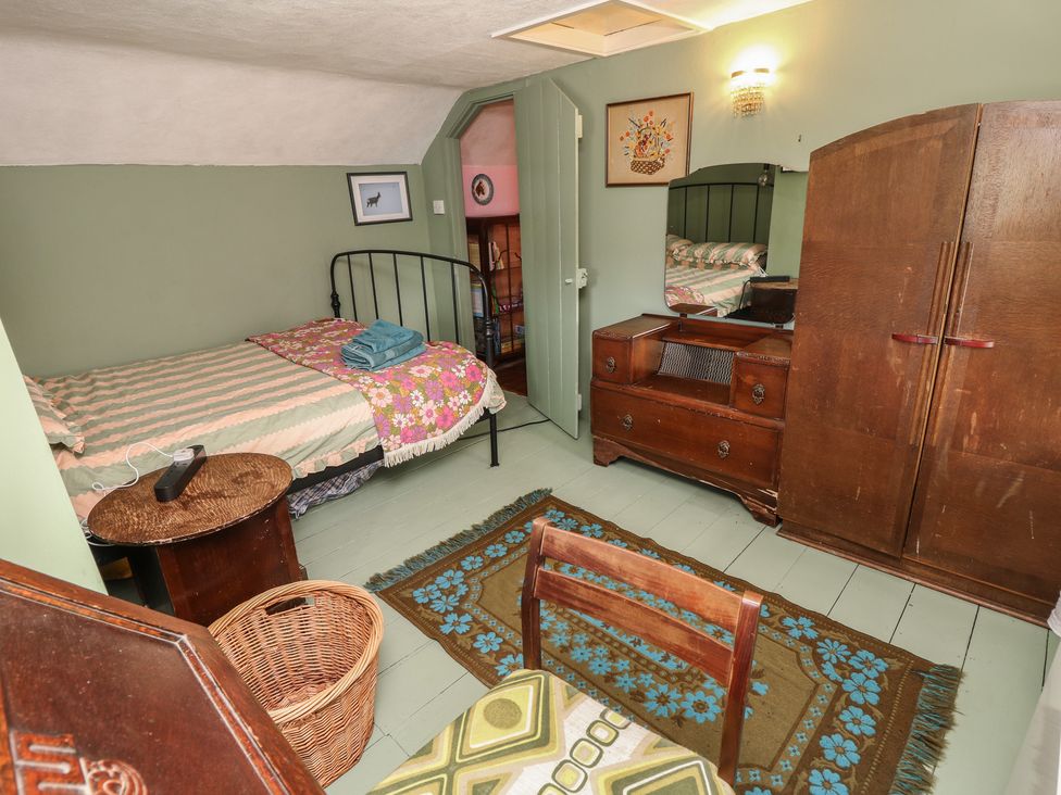 A bedroom with a bed and furniture at Dairy Cottage in Whitwell near Niton