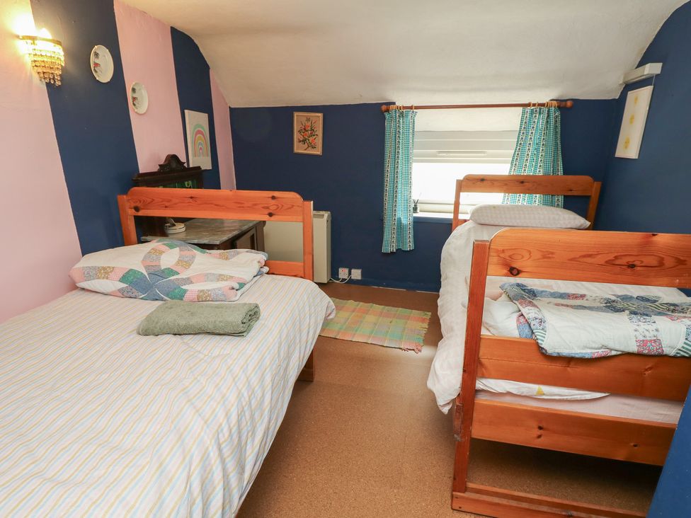 A bedroom with two beds and a window at Dairy Cottage Whitwell near Niton