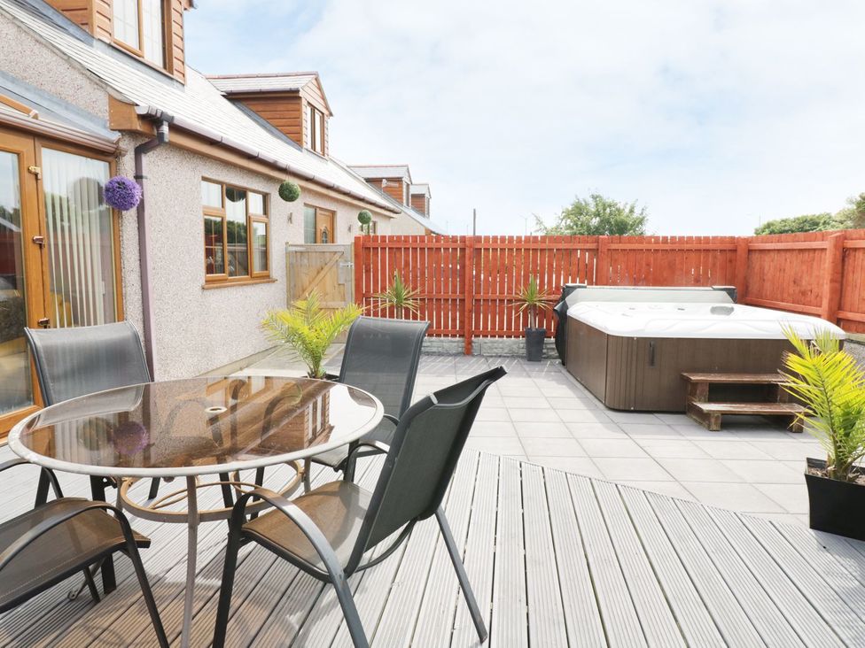 An outdoor area with a dining table and chairs at 1 The Old Smithy Cemaes Bay