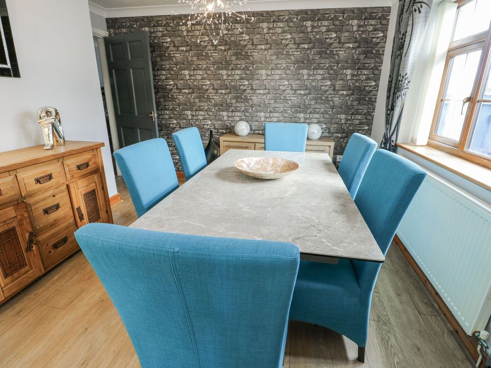 A dining room with a table and chairs at 1 The Old Smithy Cemaes Bay