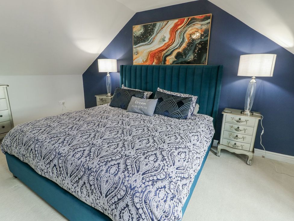 A bedroom with a bed and bedside tables at 1 The Old Smithy in Cemaes Bay
