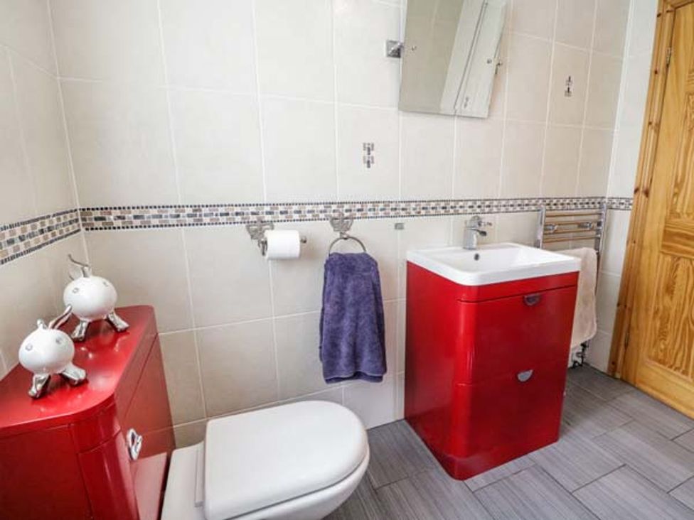 A bathroom with a sink, toilet, and towel rack at 1 The Old Smithy Cemaes Bay