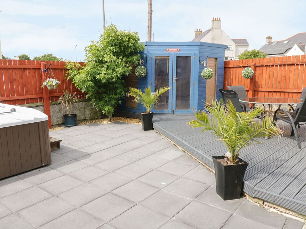 A garden with a hot tub and a blue shed at 1 The Old Smithy Cemaes Bay