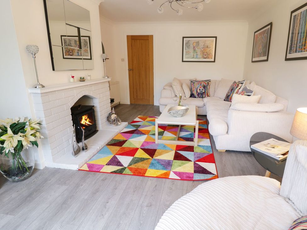 A living room with a fireplace and a sofa at Gwelfor in Cemaes Bay