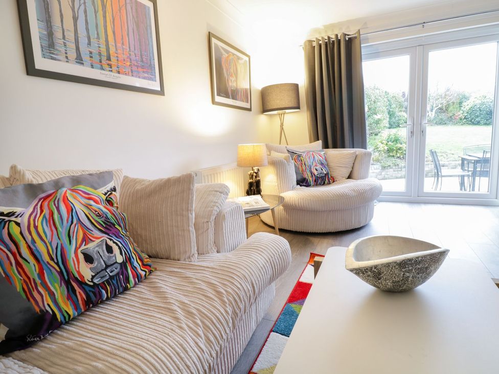 A living room with sofas and a garden view at Gwelfor in Cemaes Bay