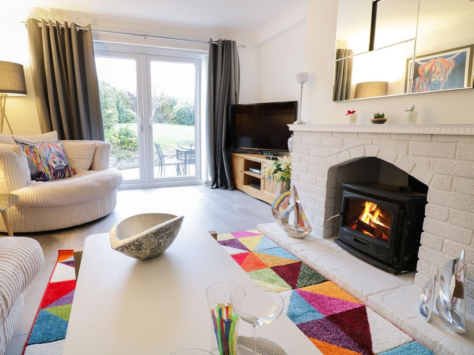 A living room with a fireplace and sofa at Gwelfor in Cemaes Bay