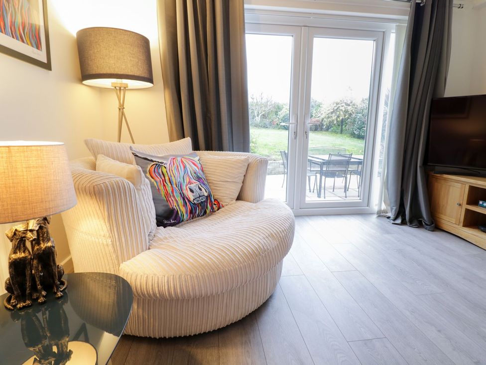 A living room with a sofa and television at Gwelfor in Cemaes Bay