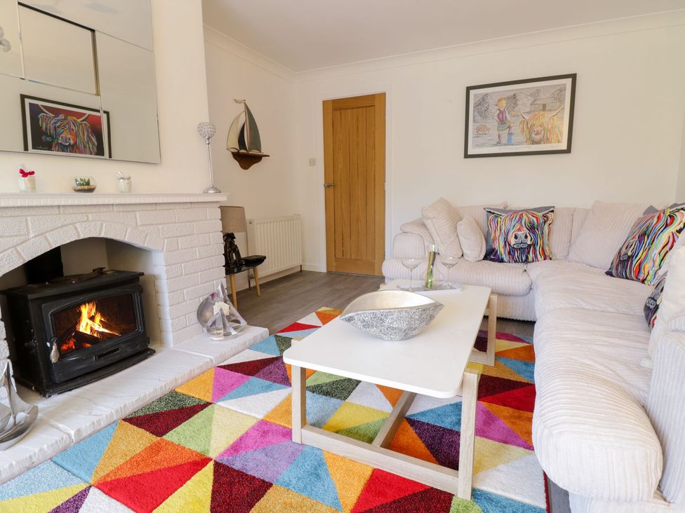A living room with a fireplace and sofa at Gwelfor in Cemaes Bay