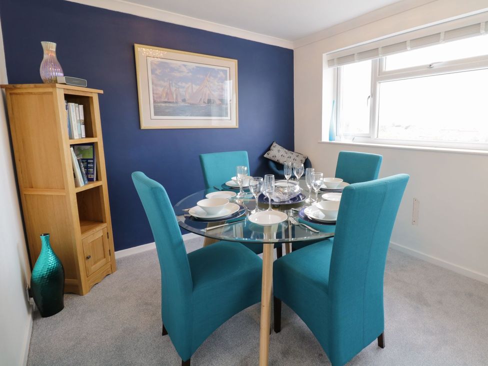 A dining room with a glass table and chairs at Gwelfor in Cemaes Bay