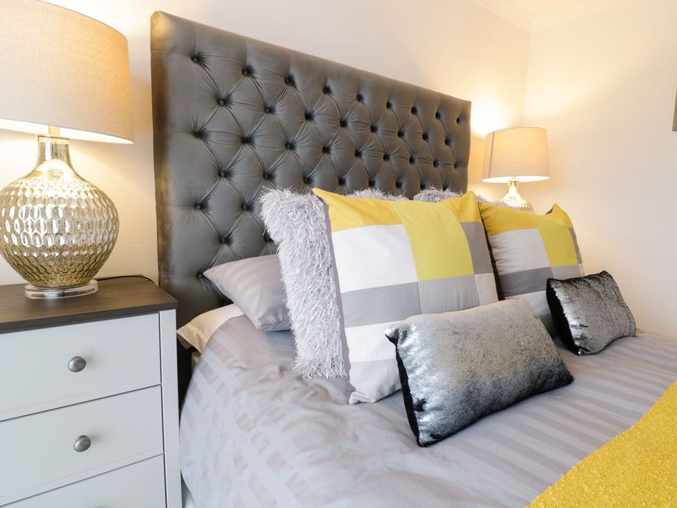 A bedroom with a bed and pillows at Gwelfor in Cemaes Bay
