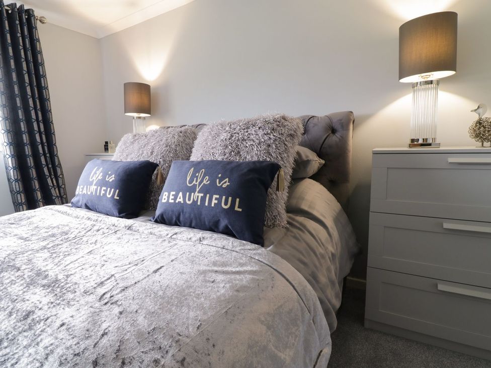 A bedroom with a bed and pillows at Gwelfor in Cemaes Bay