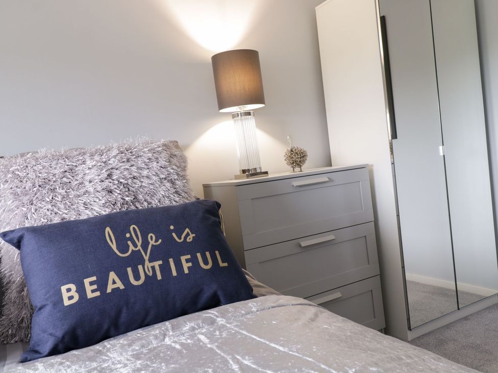A bedroom with a pillow and lamp at Gwelfor in Cemaes Bay